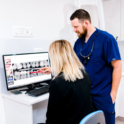 Dentist showing wisdom tooth X-ray during consultation at Cleveland Dental Care